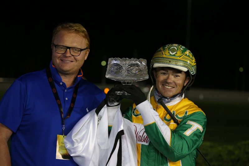 Driver Tim Tetrick poses with the Milton Stakes trophy and Mayor of Milton, Gordon Krantz after winning with Lyons Sentinel. (New Image Media) 